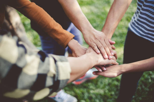 stacking hands of young teen student, teamwork, togetherness and cooperation concept - volunteer imagens e fotografias de stock