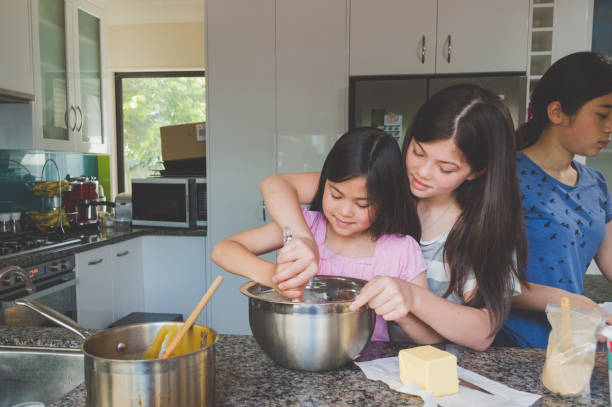 mädchen in der küche kochen - eurasian ethnicity stock-fotos und bilder