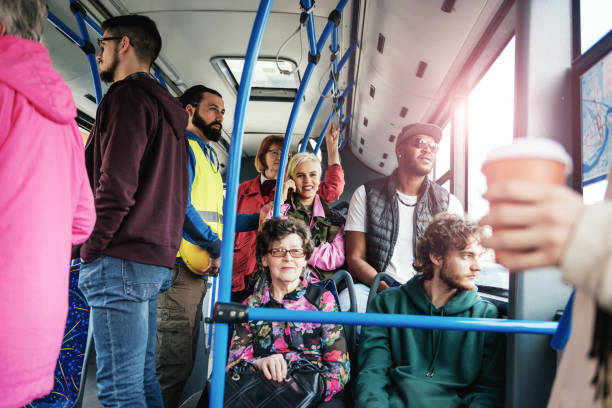 istock Senior woman sitting in crowded public bus 985577334