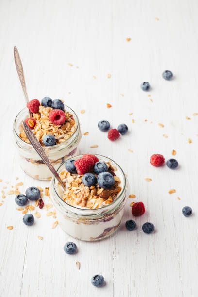 istock Granola with berries and yogurt in jars. 985577872