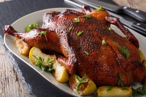 istock Beautiful food: baked whole duck with apples close-up on a platter. horizontal 985580790