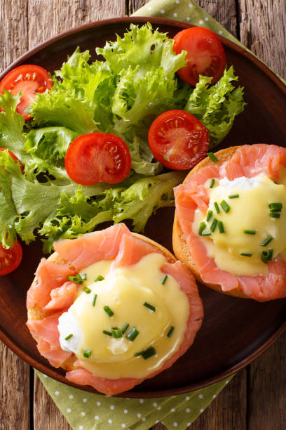 istock Eggs Benedict with salmon and hollandaise sauce close-up. Vertical top view 985581244
