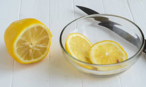 istock One cutted lemon and two slices of lemon into glass plate. 985586308