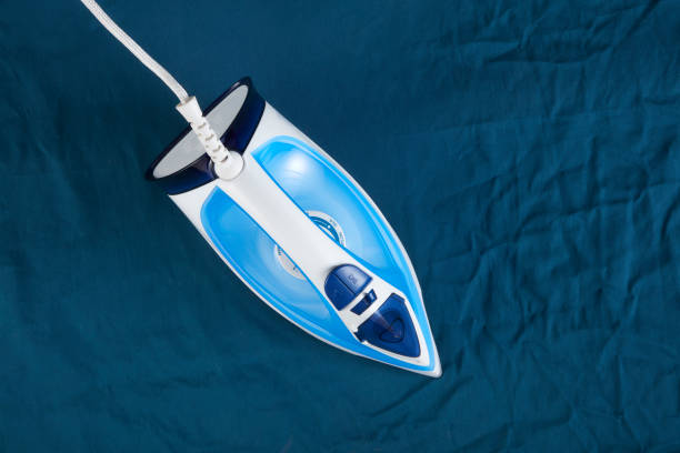 Objects: Ironing blue fabric Iron - Appliance, Clothing, Appliance, Equipment, Household Equipment drudgery photos stock pictures, royalty-free photos & images