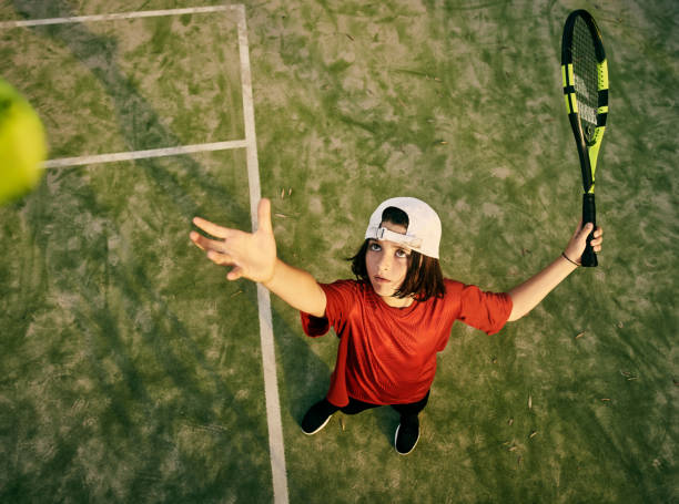 il suo gioco di servizio sul punto - tennis child teenager childhood foto e immagini stock