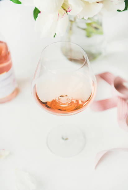 vin au verre, ruban rose, fleurs de pivoine rose - champagne wedding pink petal photos et images de collection