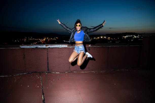 istock Cheerful young woman jumping 985592862