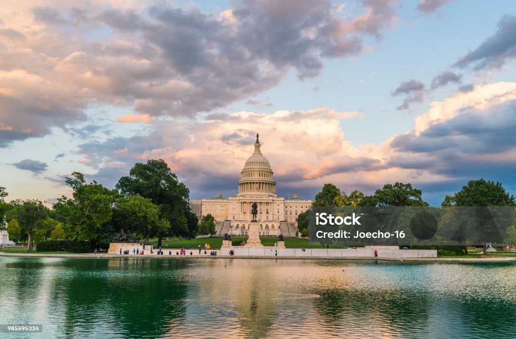 El edificio del Capitolio de Estados Unidos en la reflexión de wirh puesta de sol en el agua. - Foto de stock de Washington DC libre de derechos