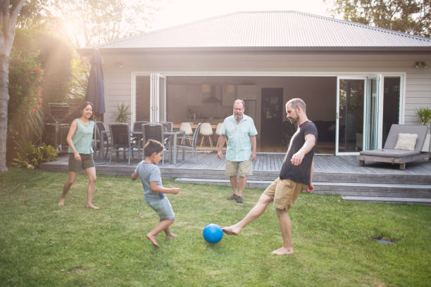 istock Multi-generation family playing soccer in yard 985596070