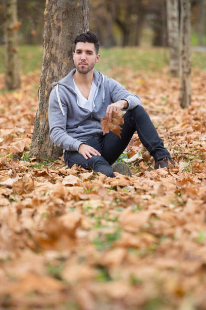 istock Handsome man in nature holding autumn leaves. Copy space 985598592