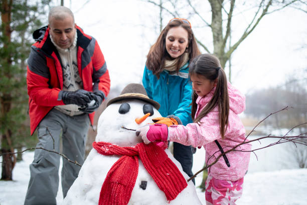 construire un bonhomme de neige avec sa famille - making memories photos et images de collection