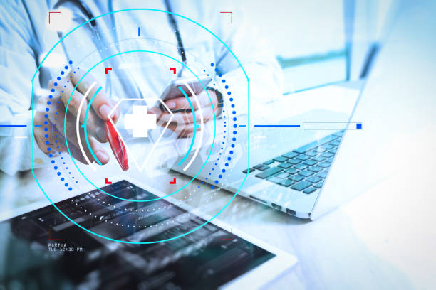 istock Medical technology concept. Doctor hand working with modern digital tablet and laptop computer with medical chart interface, Sun flare effect photo 985605108
