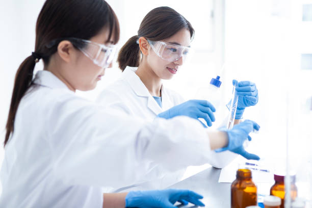 istock A woman wearing protective equipment which is experimenting with liquid. 985605120