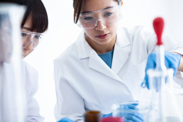 istock A woman wearing protective equipment which is experimenting with liquid. 985605156