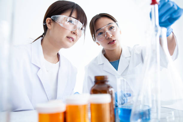 istock A woman wearing protective equipment which is experimenting with liquid. 985605186
