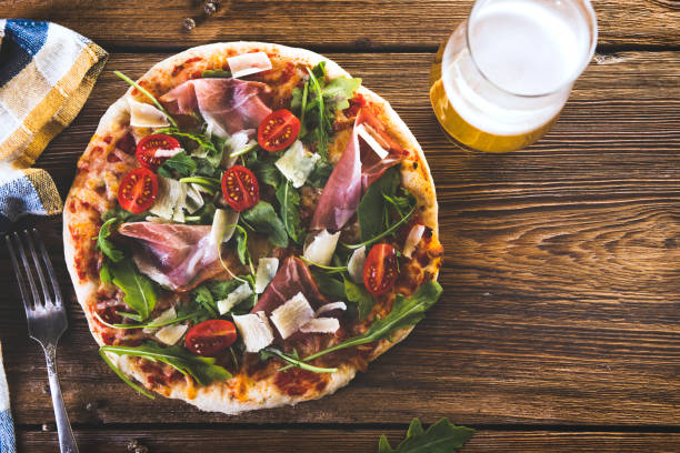 istock Homemade Pizza on wooden table with Beer 985605772