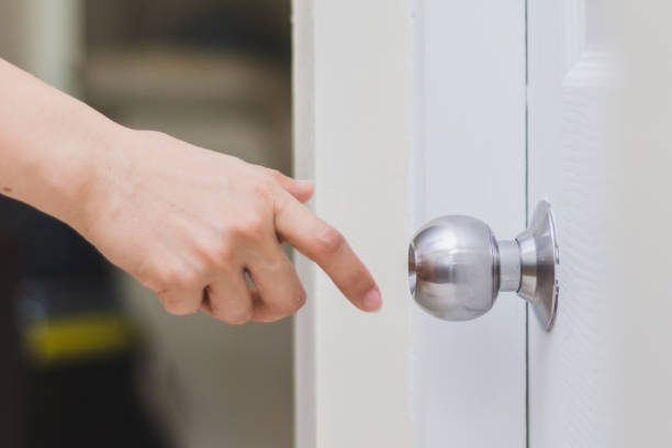 close up of woman’s hand reaching to door knob, opening the door close up of woman’s hand reaching to door knob, opening the door doorknob photos stock pictures, royalty-free photos & images