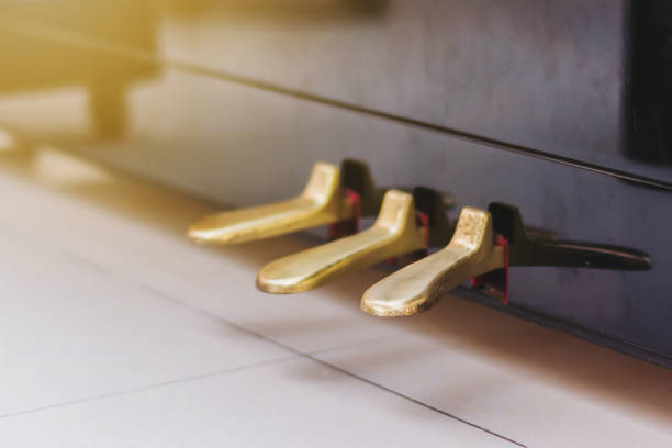 goldene klavier pedale auf boden mit gradien klavier steht - piano pedal stock-fotos und bilder