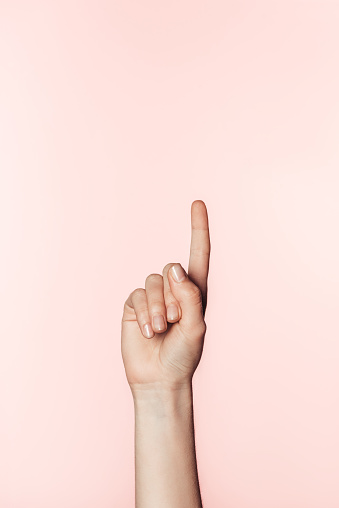cropped image of woman doing finger raised gesture isolated on pink background