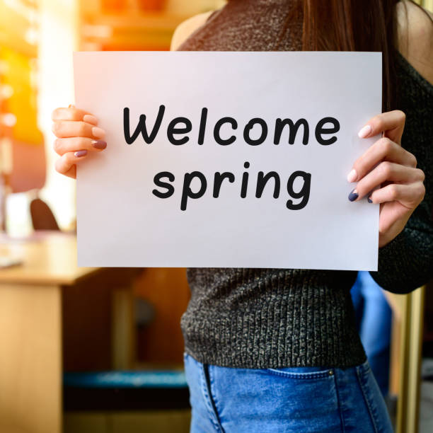 istock Slim brunette girl holding paper with Welcome Spring  phrase in 985627670