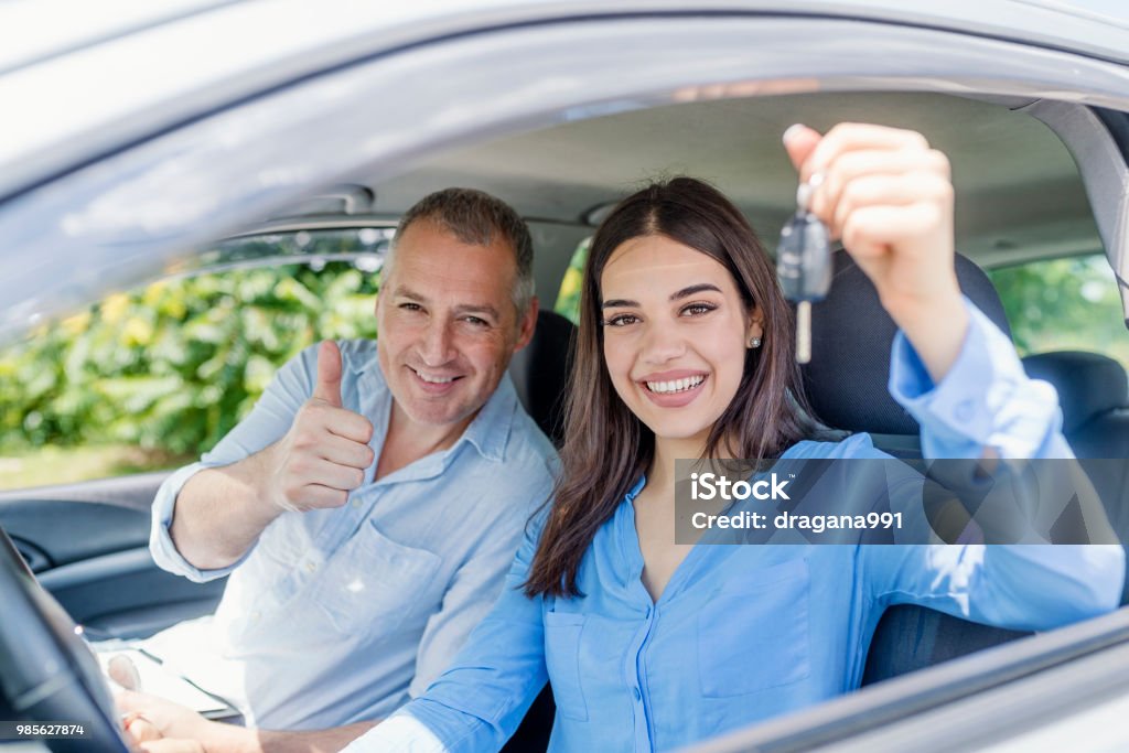 Young woman delighted having just passed her driving test Young woman delighted having just passed her driving test.  Positive face expression Driving Stock Photo