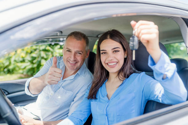 Young woman delighted having just passed her driving test Young woman delighted having just passed her driving test.  Positive face expression driving test photos stock pictures, royalty-free photos & images