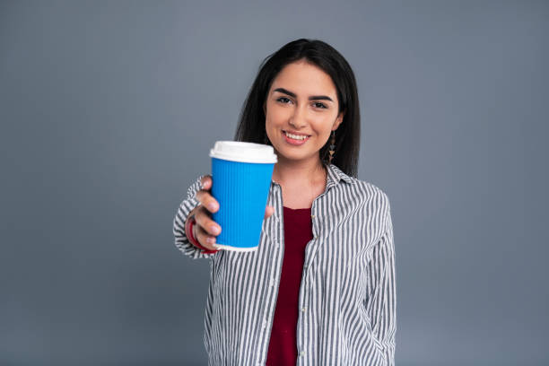 istock Charming dark-haired woman showing a blue coffee cup 985629544