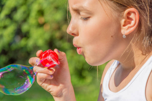 istock Child girl blowing bubbles 985633698