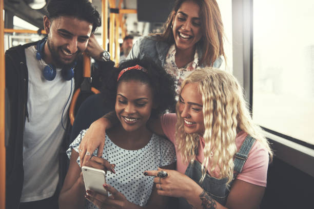 istock Smiling group of friends using a cellphone on the bus 985665004