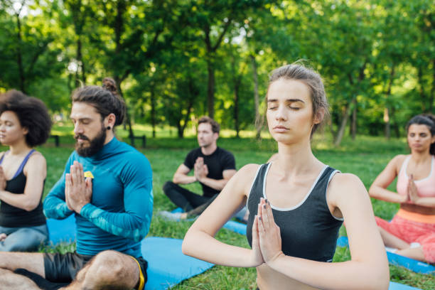 istock People exercising yoga at the park 985671350