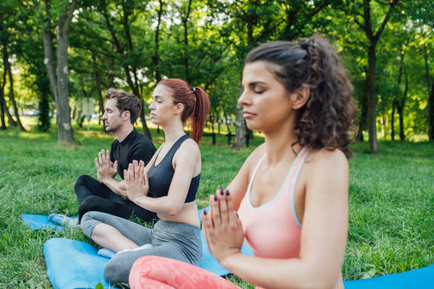 istock Multi-gender group of people exercising yoga 985671382