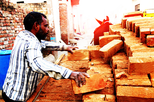 Bricklayer or mason laying bricks to build wall. Bricklaying contractor doing precision masonry wall concept