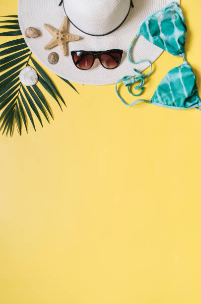 istock Beach apparel and tropical leaves arranged on yellow background 985676104