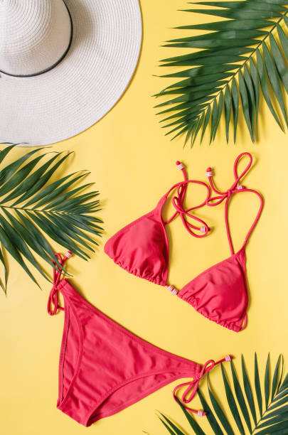 istock Beach apparel and tropical palm leaves arranged on yellow background 985676124