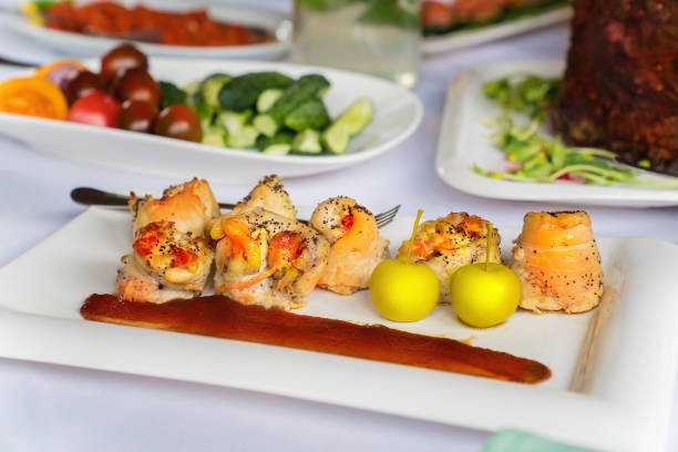 istock Chicken breast rolls with apples and sauce on a white plate on a table. 985676574