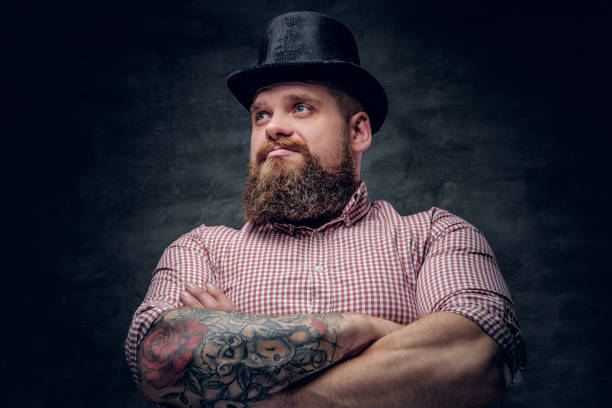 istock Bearded male with crossed tattooed arms 985695648