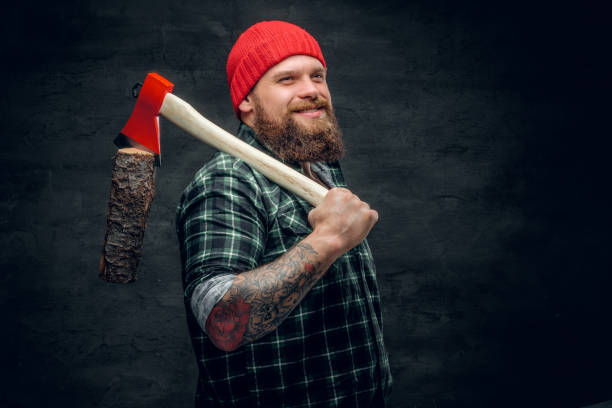 istock Lumberjack dressed in a green shirt holds the red axe. 985705722