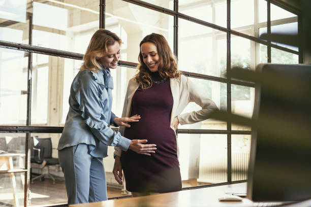 istock Vigorous colleague supporting pregnant woman 985708464