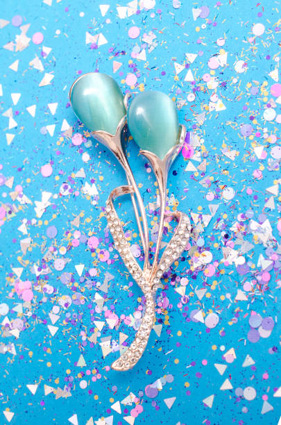 istock gold brooch flower with blue moon stone in spangles isolated on blue background 985713270