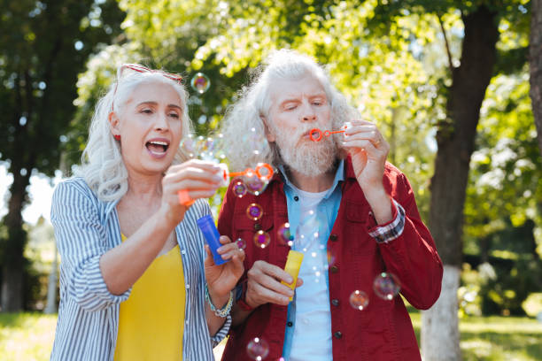 istock Nice happy couple blowing soap bubbles 985714504