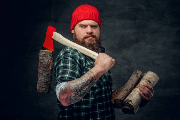 istock Lumberjack dressed in a green shirt holds the red axe. 985756806
