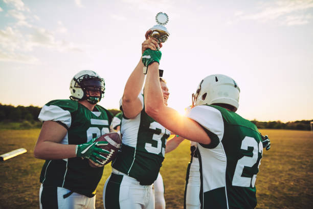 istock Football team celebrating with a trophy after winning the championship 985756830