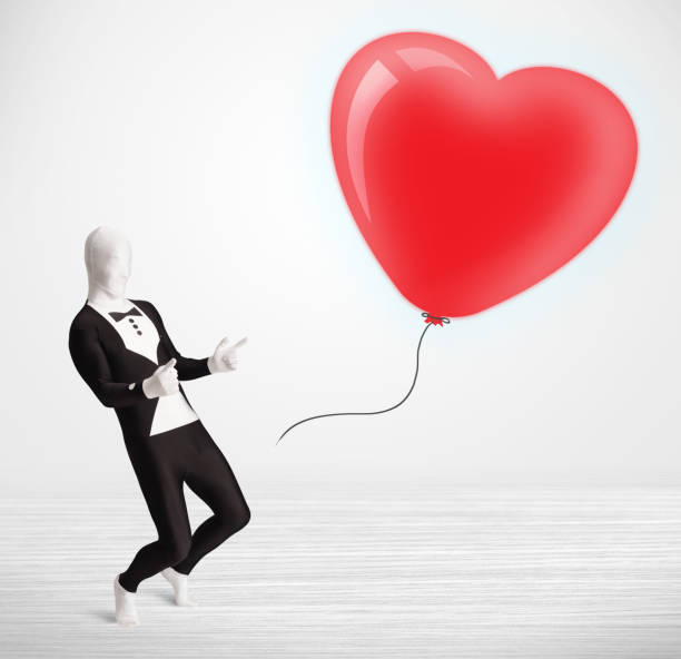 istock Cute guy in morpsuit body suit looking at a balloon shaped heart 985758230
