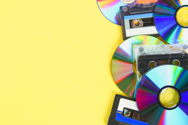 istock CD disks and audio cassettes on a yellow pastel background. Minimalism. 985761604
