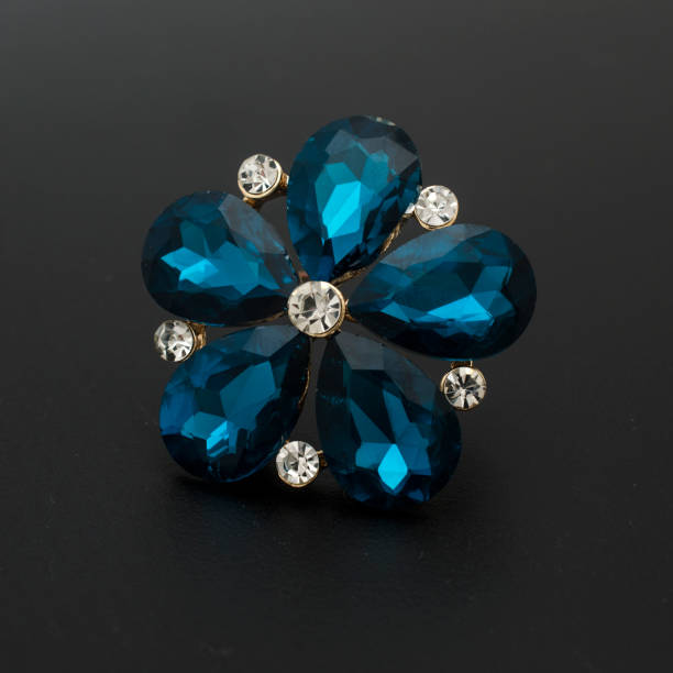 istock brooch flower with blue stones isolated on black 985762394