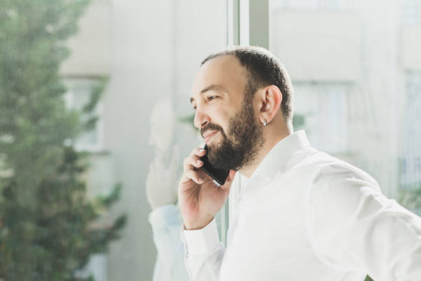 istock Businessman talking on the phone near window 985762720