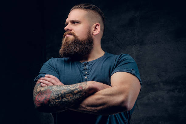 istock Bearded male with tattooed crossed arms. 985779638