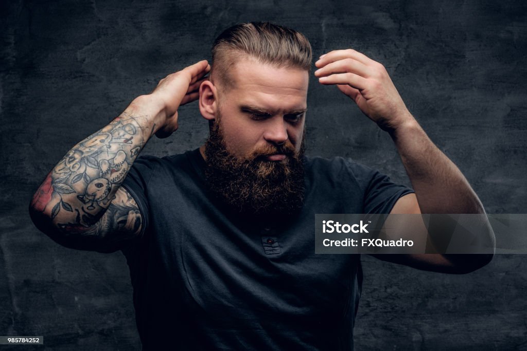Bearded Male Touches His Hairstyle With Tattooed Arms Stock Photo - Download Image Now - iStock Bearded Male Touches His Hairstyle With Tattooed Arms Stock Photo - Download Image Now - iStock