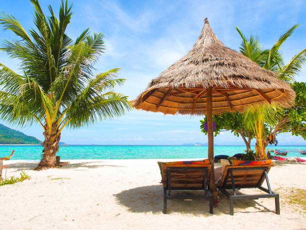 istock Beach chairs and parasol on white sand beach at sea. 985784456