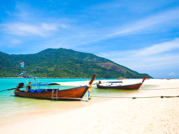 istock Wooden long tail boat at blue sea. 985784500